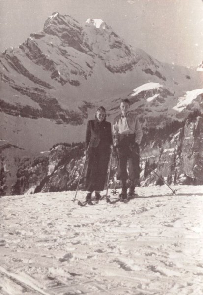 Mann und Frau mit Ski auf der Alp