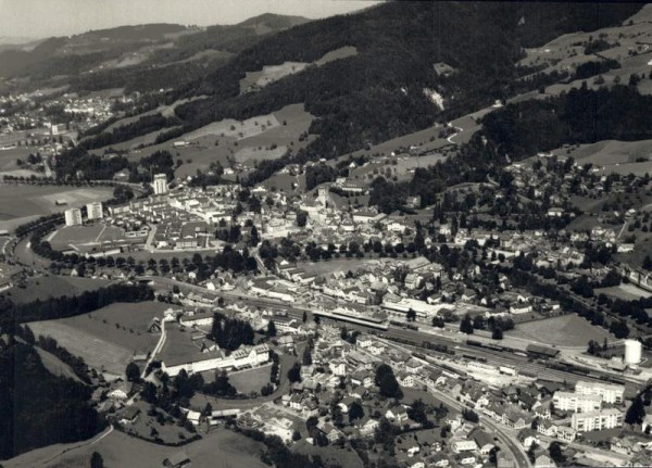 9630 Wattwil, Bahnhof / Thur / Hintergrund: Hochhaus 1+2 / Schulhaus Grüenau / evang. Kirche Vorderseite